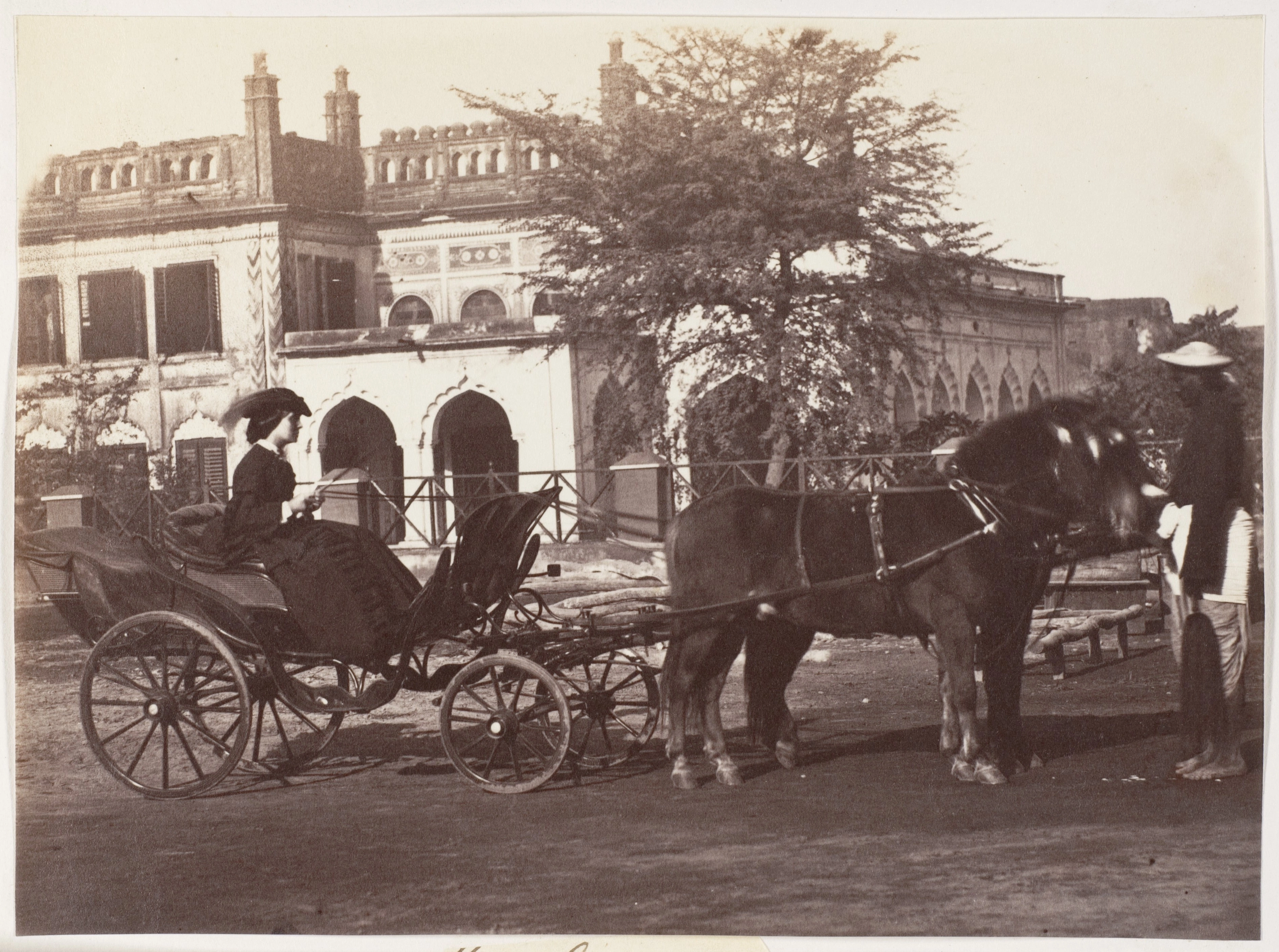 A carriage and pair drawn up before the gates of a stone house